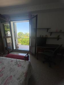 a bedroom with a bed and a desk and a window at Villa Familia in Écija