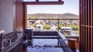 a bath tub with a view of a city at Sora Niwa Terrace Kyoto Bettei in Kyoto
