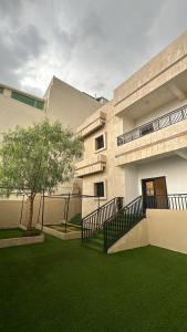 budynek z zielonym trawnikiem przed nim w obiekcie فيلا ممشى الضباب w mieście Abha