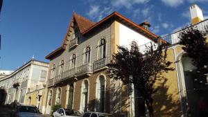 un grande edificio con auto parcheggiate di fronte di Casa Ocre Alojamento Local ad Abrantes Altre 10 foto