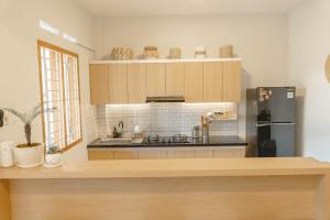 a kitchen with a stove and a refrigerator at Ninap hostel in Banyuwangi