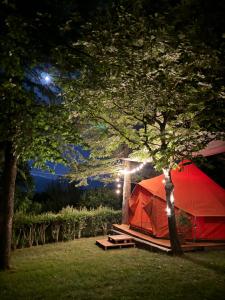 a red tent sitting next to a tree at night at Glamping Marche Nascoste Tenda e intero alloggio in Penna San Giovanni