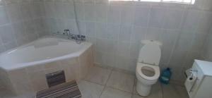 Un baño con bañera, inodoro y lavabo. en Thokgamo Bed and Breakfast, en Kanye 6 fotos más
