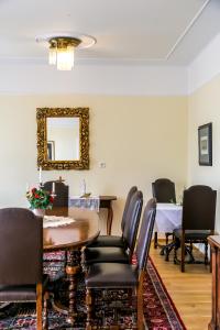 a dining room with a table and chairs and a mirror at Villa Thalhof in Bad Gleichenberg