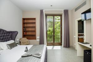 a bedroom with a bed and a sliding glass door at Les Clarisses Boutique Hotel in Vic