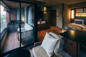 a room with a bed and a bedroom with a tub at Sora Niwa Terrace Kyoto Bettei in Kyoto