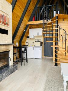 a kitchen and dining room with a fireplace and a staircase at Sardunya Bungalov in Sapanca