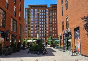 a city street with buildings and tables and a person on a bike at Superb 1 bedroom in the best zone of the city. in Ferizaj