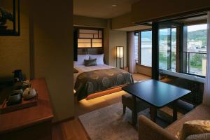 a bedroom with a bed and a table in a room at Sora Niwa Terrace Kyoto Bettei in Kyoto