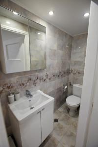 Un baño con un lavabo blanco y un inodoro. en Casa Di Nafplio, en Nauplia 11 fotos más