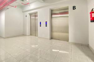 un couloir avec deux portes d'ascenseur dans un immeuble dans l'établissement Apartment Riverdale by Dani room, à Tanahbaru