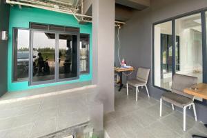 une chambre avec deux chaises, une table et des fenêtres dans l'établissement Apartment Riverdale by Dani room, à Tanahbaru 1 autre photo