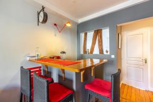 jadalnia z drewnianym stołem i czerwonymi krzesłami w obiekcie GuestReady - Amazing stay in the 19th arr. w Paryżu