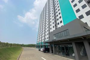 un grand bâtiment avec un parking en face de celui-ci dans l'établissement Apartment Riverdale by Dani room, à Tanahbaru