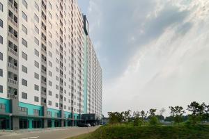 un grand bâtiment avec un poteau vert à côté d'une rue dans l'établissement Apartment Riverdale by Dani room, à Tanahbaru