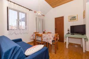 a living room with a blue couch and a table at Apartmány Viktor in Selca kod Bogomolja