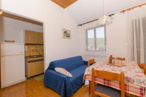 a living room with a table and a blue couch at Apartmány Viktor in Selca kod Bogomolja