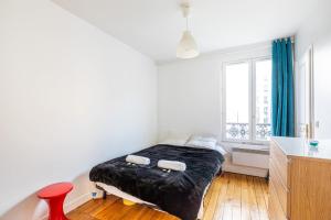 sypialnia z łóżkiem i czerwonym krzesłem w obiekcie GuestReady - Amazing stay in the 19th arr. w Paryżu