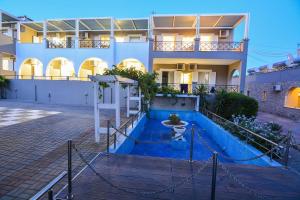 a house with a blue pool in front of it at Epavlis Beach Resort in Porto Heli