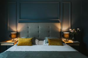 a bedroom with a large bed with two lamps at Hotel Wawel Queen in Krakow