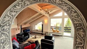 un arco en una sala de estar con mesa y sillas en Chesa Bellaval, Haus Leivra 6½-Zimmerwohnung, en Silvaplana