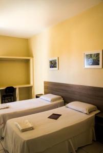 a hotel room with two beds in a room at Hotel Melo in Montes Claros