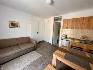 a living room with a couch and a kitchen at Tip- top in Karlobag