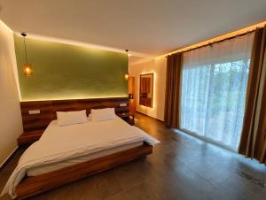 a bedroom with a bed and a large window at Malgudi Farms in Bangalore