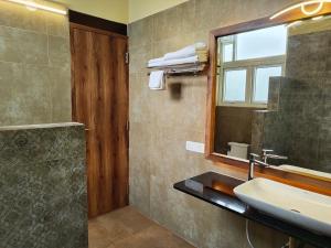a bathroom with a sink and a mirror at Malgudi Farms in Bangalore