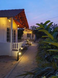 a porch of a house with lights on it at Malgudi Farms in Bengaluru