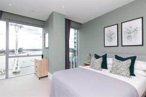a bedroom with a large bed and a large window at Greenwich-the 02 two in London