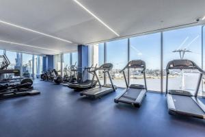 a gym with cardio equipment in a building with windows at Greenwich-the 02 two in London