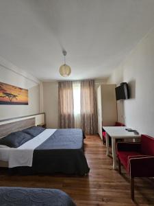 una camera d'albergo con un letto, un tavolo e una scrivania di Hotel 045 a Shkodër