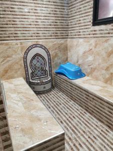 y baño con ducha y asiento azul. en Ferme Amir, en Rabat
