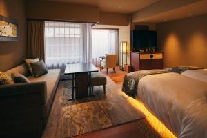a hotel room with a bed and a couch at Sora Niwa Terrace Kyoto Bettei in Kyoto
