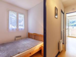 a bedroom with a bed and two windows at Appartement cosy Cauterets, balcon sud, proche centre & télécabine, 4 pers, parking inclus - FR-1-401-15 in Cauterets