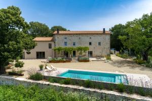 an estate with a swimming pool in front of a building at Villa Batalini in Šumber