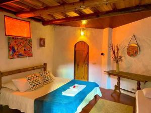 une chambre avec un lit avec une couverture bleue dans l'établissement Pousada Econois, à Alto Paraíso de Goiás