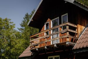 a building with a balcony on the side of it at Domki u Serowarki z Jacuzzi w cenie in Polańczyk