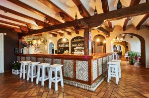 a restaurant with a bar with white stools at Hotel Risco in Laredo