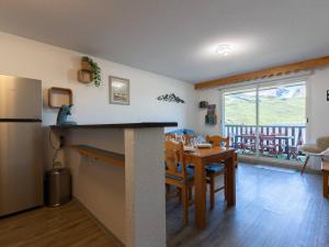 a kitchen and dining room with a table and a refrigerator at Appartement Rénové Peyragudes - 8 Pers, Balcon, 2 Chambres + Cabine, Parking Gratuit, Proche Pistes - FR-1-695-10 in Germ +9 photos