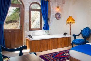 a bath tub in a room with a window at Black Stove Cappadocia in Ortahisar