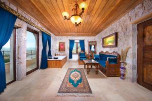 a living room with a blue couch and a wooden ceiling at Black Stove Cappadocia in Ortahisar