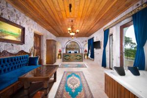 a living room with a blue couch and a table at Black Stove Cappadocia in Ortahisar