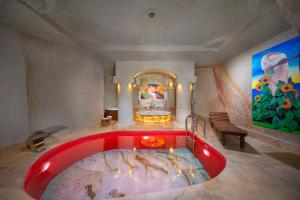 a large red bath tub in a room with a painting at Black Stove Cappadocia in Ortahisar