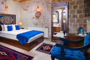 a bedroom with a bed and a desk and a mirror at Black Stove Cappadocia in Ortahisar