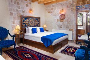 a bedroom with a bed and a stone wall at Black Stove Cappadocia in Ortahisar