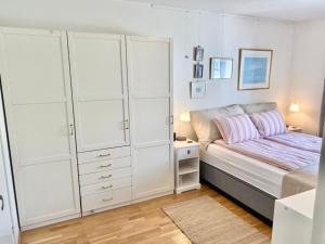 a white bedroom with a bed and a dresser at Spacious 3 Bedroom next to Thon Hotel, Storsenter Shopping, and 15 minutes to Oslo in Sandvika