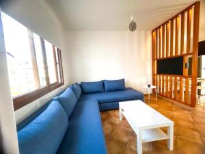 a living room with a blue couch and a table at Appartement Familial - CaboNegro in Cabo Negro
