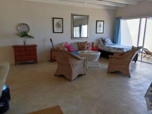 a living room with wicker chairs and a couch at Galene Beach Cottage in Port Shepstone